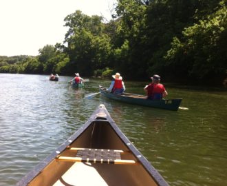 someone in a canoe took picture of three canoes with friends up ahead in the water Downriver Canoe Company Shenandoah Valley River