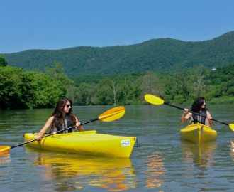 two sisters navigate their kayaks with paddles Downriver Canoe Company Shenandoah Valley River