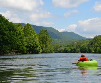 a young person tubing down very calm waters while enjoying the scenery Downriver Canoe Company Shenandoah Valley River